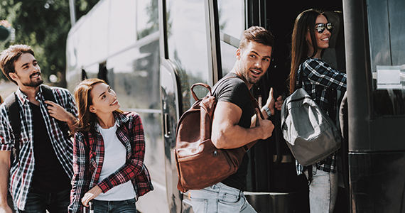 Happy people boarding a Miami charter bus rental 
